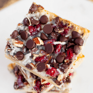 Dark Chocolate Cranberry Magic Bars are a symphony of flavors and textures, perfect for the holiday baking season! Easy to make and beyond delicious! #christmasdessert #thanksgivingdessert #holidaybaking #cranberrydessert
